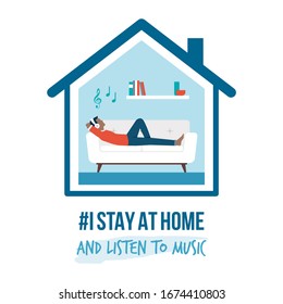 I stay at home awareness social media campaign and coronavirus prevention: man lying on the sofa and listening to music - Shutterstock ID 1674410803