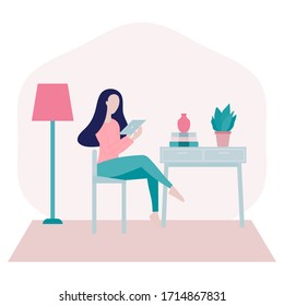 Stay home concept.Young woman sitting on a chair at home and surfing on internet,shopping online using her 
tablet in period of self isolation and social distancing during Covid-19 epidemic.
