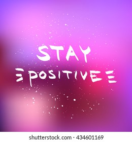 Stay Positive lettering. Motivational quote on blurred background.
