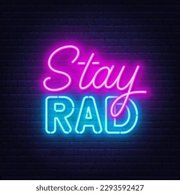 Stay Rad neon quote on brick wall background.