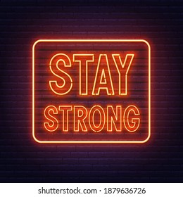 Stay strong neon inspirational quote on a brick wall.