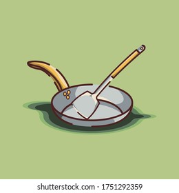 steel spatula in top of steel frypan on green light background