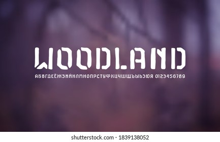 Stencil-plate cyrillic sans serif font in the style of hand drawn graphic. Letters and numbers for logo and t-shirt design. White print on blurred background