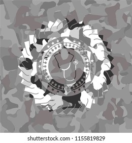 stethoscope icon inside grey camo emblem