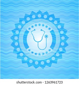 stethoscope icon inside sky blue water wave emblem.