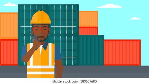 Stevedore standing on cargo containers background.