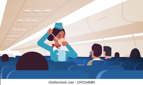 stewardess explaining for passengers how to use oxygen mask in emergency situation african american flight attendant safety demonstration concept modern airplane board interior horizontal vector