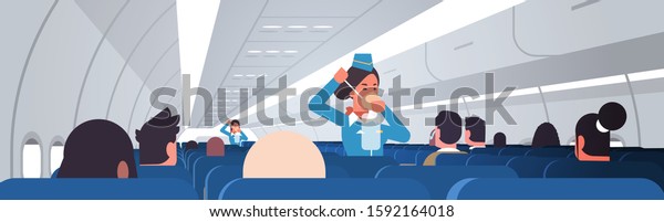stewardess explaining for passengers how to\
use oxygen mask in emergency situation flight attendants safety\
demonstration concept modern airplane board interior horizontal\
vector illustration