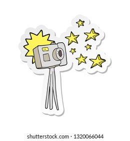 sticker of a cartoon camera on tripod with flash
