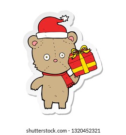 sticker of a cartoon christmas teddy bear with present