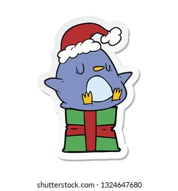 sticker of a cute cartoon penguin sitting on gift