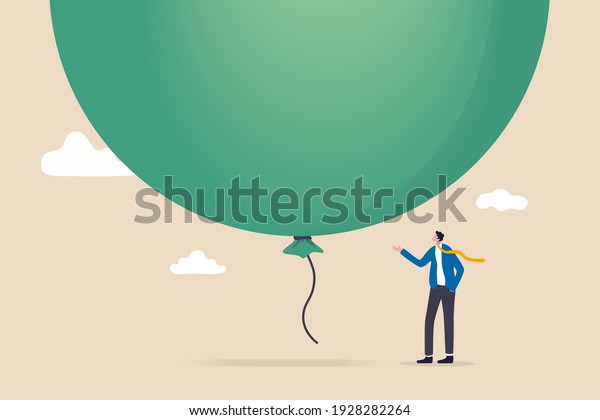 Stock market, crypto currency bitcoin bubble,\
risk of speculation investment, big debt balloon ready to burst\
concept, fearful businessman investor standing under huge big air\
balloon bubble.