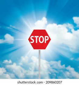 Stop Sign and blue sky with clouds and sun ray