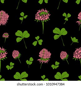 St.Patrick's day background. Seamless pattern with the leaves and flowers of clover on a black background. Vector.