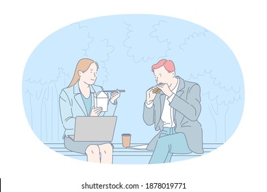 Street food, Unhealthy eating, calories concept. Young business couple office workers sitting and eating burger and noodles in park during lunch break. Overweight, snack, lifestyle, harmful eating