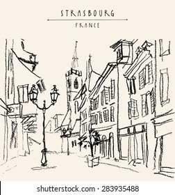 Street in old town center of Strasbourg, Bas Rhin, France. Historical buildings, church, shops and lights. Vector freehand drawing with black charcoal on paper. Travel sketch postcard design template