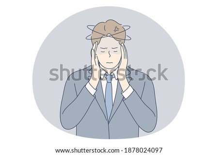 Stress, overwork, overload concept. Unhappy depressed stressed young businessman office worker touching head with fingers, feeling headache, stressed and tired in office. Exhaustion, depression 