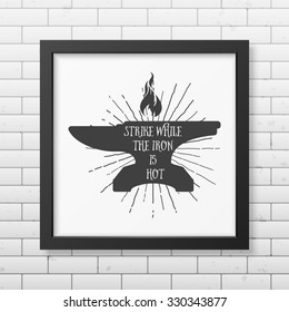 Strike while the iron is hot - Quote typographical Background in realistic square black frame on the brick wall background. Vector EPS10 illustration. 