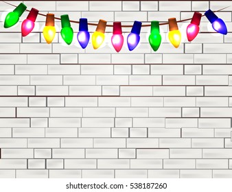 String of Color christmas light bulbs  on white brick background. eps10