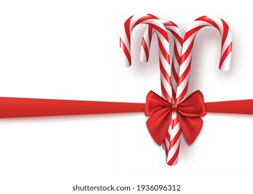 Striped candy canes wrapped in realistic red silk ribbon bow