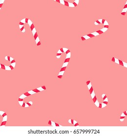 Striped candy stick in red and white colors seamless pattern isolated on pink. Endless texture with traditional Christmas lollipop vector illustration. Tasty dessert, ornamental confectionery treat