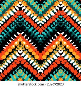 Striped hand painted vector seamless pattern with ethnic and tribal motifs, zigzag lines, brushstrokes and splatters of paint in multiple bright colors for summer fall fashion