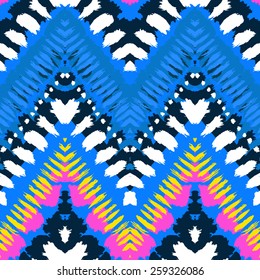 Striped hand painted vector seamless pattern with ethnic and tribal motifs, zigzag lines, brushstrokes and splatters of paint in multiple bright colors for summer fall fashion