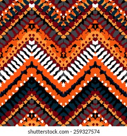 Striped hand painted vector seamless pattern with ethnic and tribal motifs, zigzag lines, brushstrokes and splatters of paint in multiple bright colors for summer fall fashion