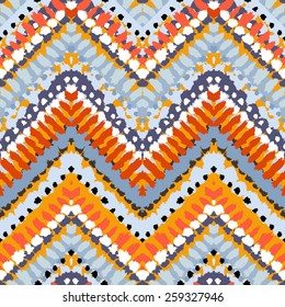 Striped hand painted vector seamless pattern with ethnic and tribal motifs, zigzag lines, brushstrokes and splatters of paint in multiple bright colors for summer fall fashion