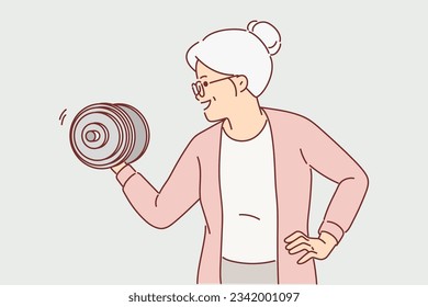 Strong grandmother lifts dumbbell wishing to remain powerful and energetic after retirement. Elderly grandmother is happy to go in for sports or fitness lifting weights to strengthen arms