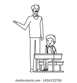 student boy seated in school desk with male teacher