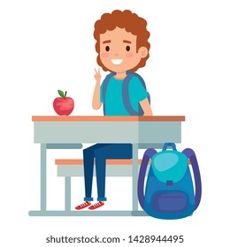 student boy seated in school desk with apple and bag