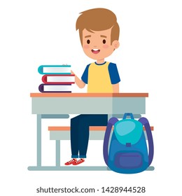 student boy seated in school desk with books and bag