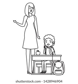 student boy seated in school desk with female teacher