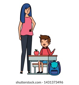 student boy seated in school desk with female teacher