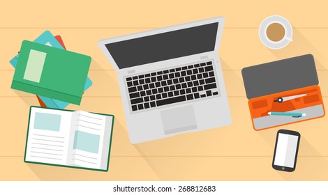 Student desktop with books, laptop, pens, phone on it.