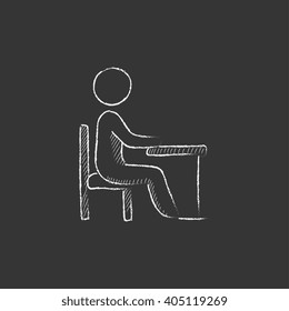 Student sitting on chair at the desk. Drawn in chalk icon.