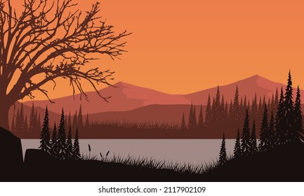 Stunning mountain views from the riverside at sunset with fantastic silhouettes of dry trees all around