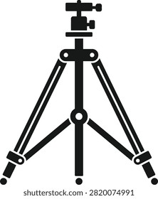 A sturdy camera tripod standing on a flat surface, ready for photography in a studio setting