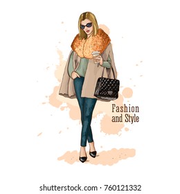 Stylish beautiful woman in fashionable clothes with bag and ?up of coffee. Fashion vector illustration. Hand drawn sketch. Dressed in slacks and coat.