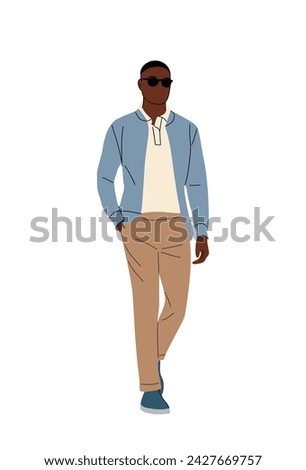 Stylish black man walking in smart casual outfit.