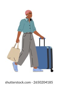 Stylish Black woman with pink short hair, headphones on neck, wearing casual unisex clothes, walking side view with suitcase and eco tote bag. Trendy travel character on white background