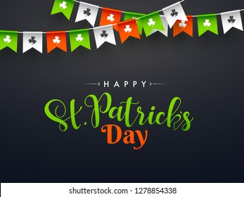 Stylish calligraphy of Happy St. Patrick's Day on black background decorated with bunting flags. Can be used as banner or greeting card design.