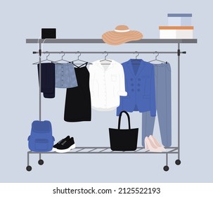 Stylish fashion clothes hanging on hangers on garment rack or rail. Fashion clothes and accessories on hanger rail. Fall, winter garments, footwear and bags. Women capsule wardrobe on racks.