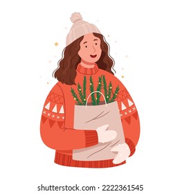 Stylish girl in a red Christmas sweater with Christmas tree branches in an eco package. New Year atmosphere. Scandinavian style.