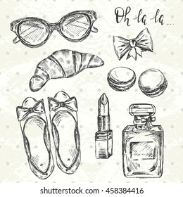 Stylish Paris set. Hand drawn shoes, glasses, lipstick, bow, macrons, croissant, perfume and text "oh la la" 