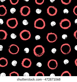 Stylish pink and white polka dot. Abstract background with round brush strokes. Hand drawn texture on black background. Dry brush and rough edges. Vector seamless pattern.
