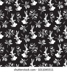 Stylish seamless pattern. Rabbits dance among flowers. Black and white.