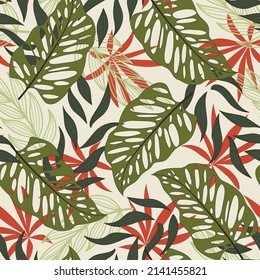 Stylish seamless tropical pattern with bright plants and leaves on a beige background. Vector design. Jungle print. Floral background. Printing and textiles.  Vintage pattern.