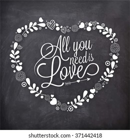 Stylish text All You Need is Love in floral decorated heart shape on chalkboard background for Happy Valentine's Day celebration.